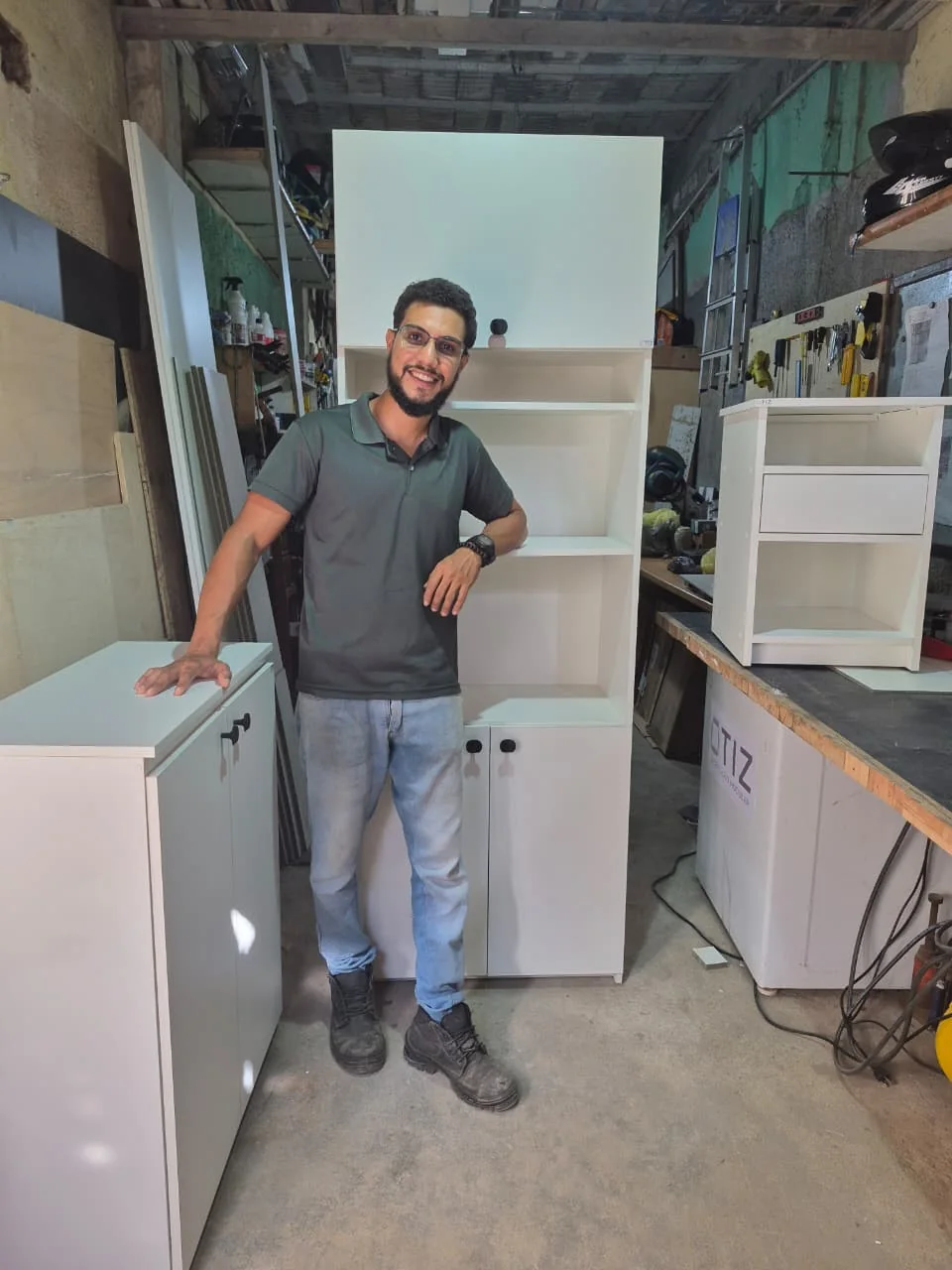 Idealizador da OTIZ na marcenaria ao lado de móveis modulados